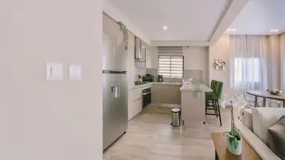 a kitchen and living room with a couch and a table at Fully Serviced Apartment at Regatta Living II - 907 in Santo Domingo