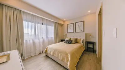 a bedroom with a bed and a large window at Fully Serviced Apartment at Regatta Living II - 907 in Santo Domingo