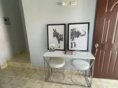 a table with two stools and three pictures on the wall at Oasis de paz 2 in Jarabacoa