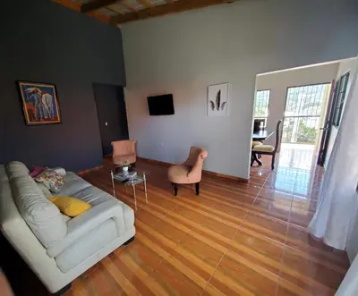 a living room with a white couch and a wooden floor at Oasis de paz 2 in Jarabacoa