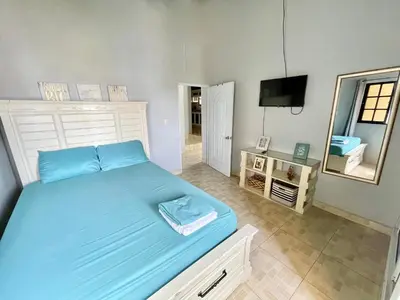a bedroom with a blue bed and a mirror at Oasis de paz 2 in Jarabacoa