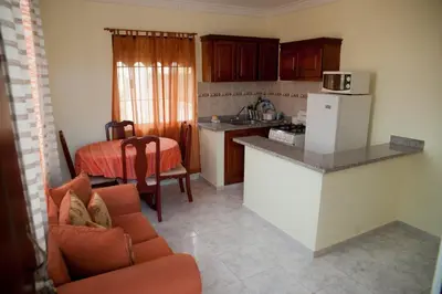 a kitchen with a couch and a table in a room at Tropical Island Aparthotel - Santo Domingo EsteRD in Santo Domingo