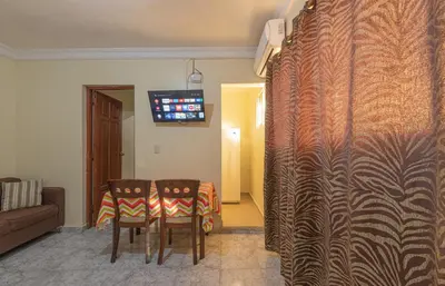 a room with a table and two chairs and a television at Tropical Island Aparthotel - Santo Domingo EsteRD in Santo Domingo