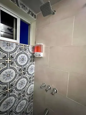 a bathroom with a shower with a tile wall at Hotel Maria Bonita Higüey in Higuey