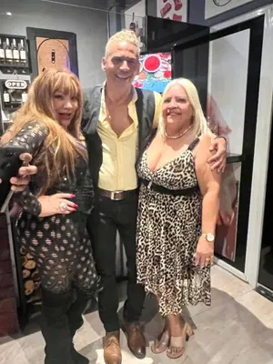 a man and two women posing for a picture at a store at Hotel Maria Bonita Higüey in Higuey