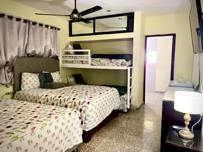 a bedroom with two beds and a ceiling fan at Hotel Maria Bonita Higüey in Higuey