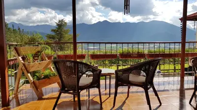 two chairs and a table on a balcony with a view at Hotel Altocerro in Constanza