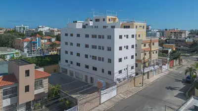 a tall white building in a city with buildings at 1-Bedroom Apartment Retreat in Santo Domingo Este in La Viva