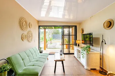 a living room with a green couch and a table at Chulavista Constanza casa campito in Arroyo Frío