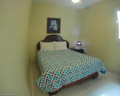 a bedroom with a bed with a bedspread on it at Hotel Renacer in Santo Domingo