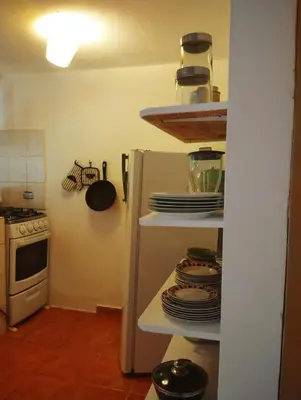 a kitchen with a refrigerator with plates and a stove at Estudio Jardín Escondido in Las Galeras