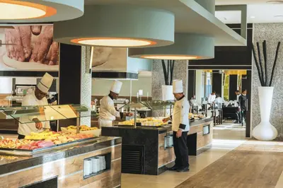 a group of chefs preparing food in a restaurant at Riu Republica - Adults Only - All Inclusive in Punta Cana
