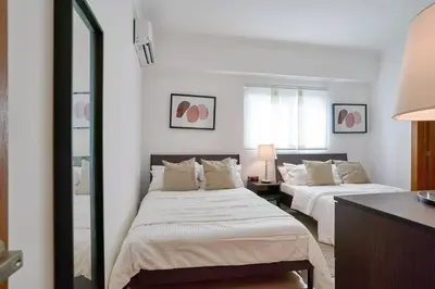a bedroom with two beds and a mirror at Escape Apartments, Balcony, Pool, Gym & Spa in La Julia in Santo Domingo