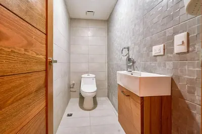 a small bathroom with a toilet and a sink at Escape Apartments, Balcony, Pool, Gym & Spa in La Julia in Santo Domingo