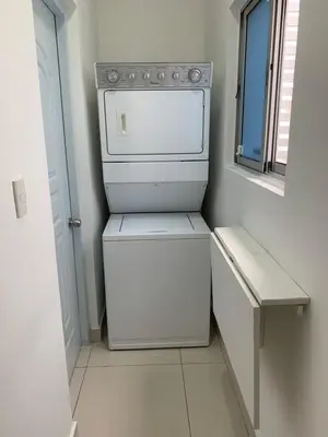 a small white refrigerator in a room with a window at Furnished Apartment - Residencial Olas - Gated Community - 24 hr Security in San Felipe de Puerto Plata