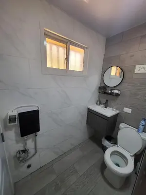 a bathroom with a toilet and a sink and a window at La casita de Gazcue in Santo Domingo
