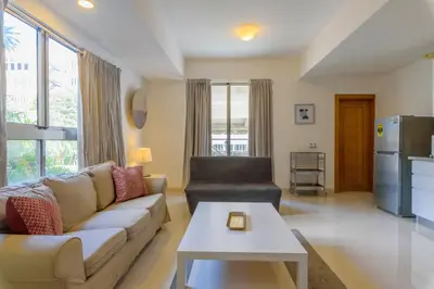 a living room with a couch and a table at Escape Apartments, Balcony, Pool & Gym in La Julia in Santo Domingo