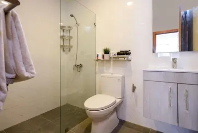 a bathroom with a toilet and a glass shower at Escape Apartments, Balcony, Pool & Gym in La Julia in Santo Domingo