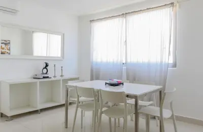 a white dining room with a white table and chairs at Escape Apartments, Balcony, Pool & Gym in La Julia in Santo Domingo