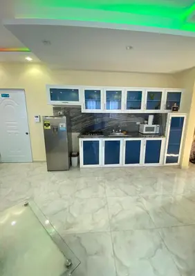 a kitchen with blue and white cabinets and a refrigerator at Cozy Apartment RM in Santiago de los Caballeros