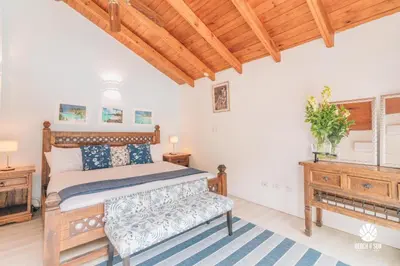 a bedroom with a bed and a bench and a window at Lux Villa Casa de Campo in La Romana