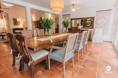 a dining room with a wooden table and chairs at Lux Villa Casa de Campo in La Romana