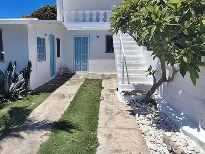 a white house with a tree in front of it at Apto Los Blancos, a dos Minuto de los Patos in Bejuquero