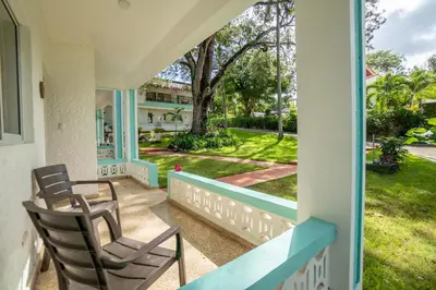 a porch with chairs and a view of a yard at Bungalow #8 at Waterfront Playa Alicia in Sosúa