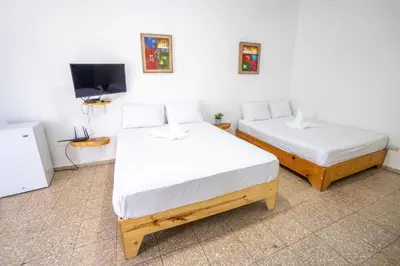 two beds in a room with a tv and a bedskirtspectspectspectspects at Room #24 at Waterfront Playa Alicia in Sosúa