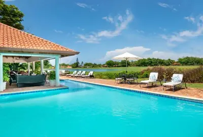 a swimming pool with chairs and umbrellas at Los Lagos 19 - Sleeps 10 - Butler - Pool Hot Tub in La Romana