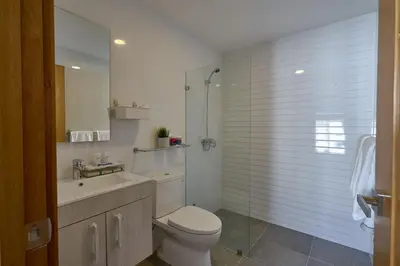a bathroom with a toilet and a sink and a shower at Apartments in La Julia 1 and 2 Bedrooms in Santo Domingo