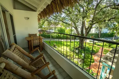 a balcony with chairs and a view of a yard at Bungalow #16 at Waterfront Playa Alicia in Sosúa