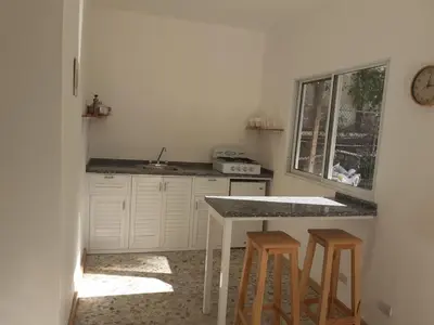 a kitchen with a sink and a counter with stools at Apartment #21 at Waterfront Playa Alicia in Sosúa