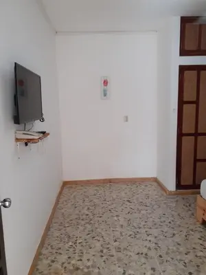 a room with a tv on a white wall at Apartment #21 at Waterfront Playa Alicia in Sosúa