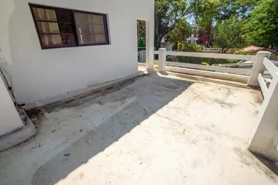 a white house with a window and a fence at Room #23 at Waterfront Playa Alicia in Sosúa