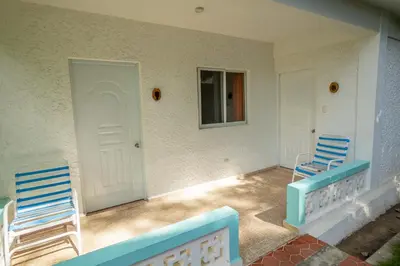 two chairs sitting on the porch of a house at Bungalow #3 at Waterfront Playa Alicia in Sosúa