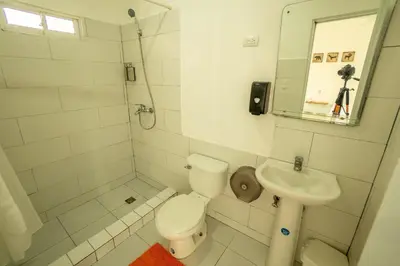 a white bathroom with a toilet and a sink at Bungalow #7 at Waterfront Playa Alicia in Sosúa