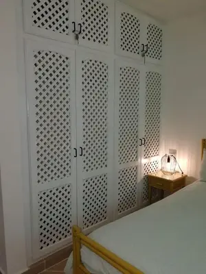 a white bedroom with a bed and a white wall at Playa Turquesa only 50m From the Beach Walk to all Restaurants in Las Terrenas