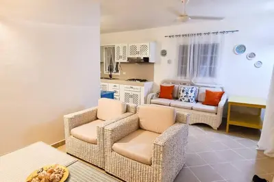 a living room with two chairs and a kitchen at Playa Turquesa only 50m From the Beach Walk to all Restaurants in Las Terrenas