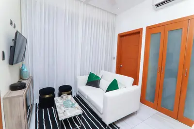 a living room with a white couch and a tv at N1401 Espectacular vista Downtown Santo Domingo RD in Santo Domingo