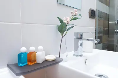 a bathroom with a shelf on a sink with a flower at N1401 Espectacular vista Downtown Santo Domingo RD in Santo Domingo