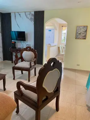 a living room with two chairs and a television at TriRoom Apartment SANTO DOMINGO ESTE in Santo Domingo