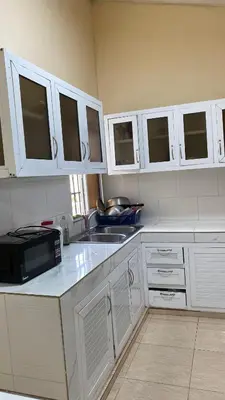 a kitchen with white cabinets and a sink and a microwave at TriRoom Apartment SANTO DOMINGO ESTE in Santo Domingo