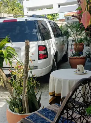 a white van parked next to a table with a cup of coffee at Villa Julirous Rd 2 bedrooms apartment in Boca Chica