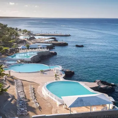 a resort with two swimming pools next to the ocean at Estudio Frente al Mar Solo Adultos in La Laguna