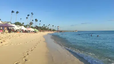a sandy beach with people swimming in the ocean at Estudio Frente al Mar Solo Adultos in La Laguna