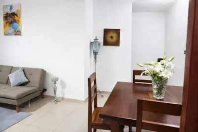 a living room with a table with a vase of flowers on it at Sol Dominicus 1 Apartamento con Cocina Solo Adultos in La Laguna