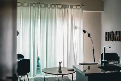 a living room with a table and a large window at ARMONIA 408 APARTMENT IN GAZCUE in Santo Domingo