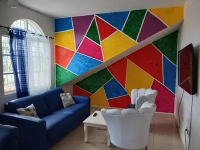 a living room with a colorful mural on the wall at Villa Boutique con Piscina Privada a Minutos del Aeropuerto SDQ in Boca Chica