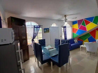 a living room with a table and a couch at Villa Boutique con Piscina Privada a Minutos del Aeropuerto SDQ in Boca Chica